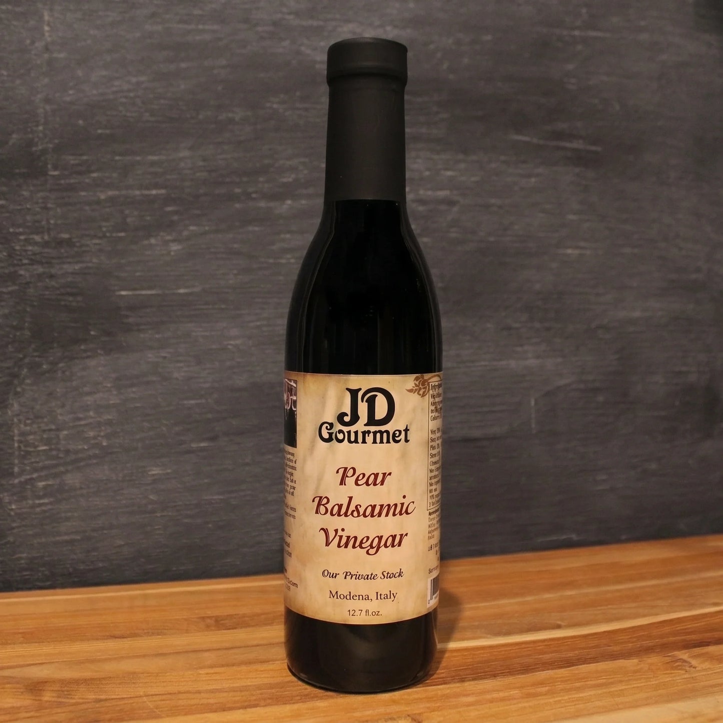 Bottle of JD Gourmet Pear Balsamic Vinegar, dark aged Modena balsamic with the JD Gourmet label