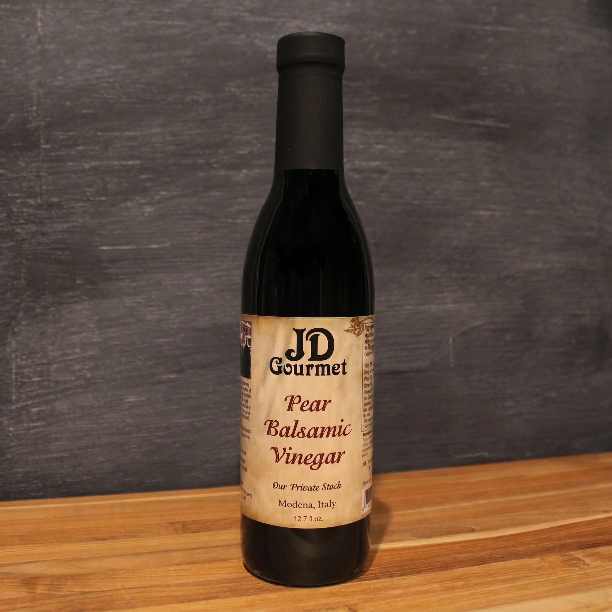 Bottle of JD Gourmet Pear Balsamic Vinegar, dark aged Modena balsamic with the JD Gourmet label