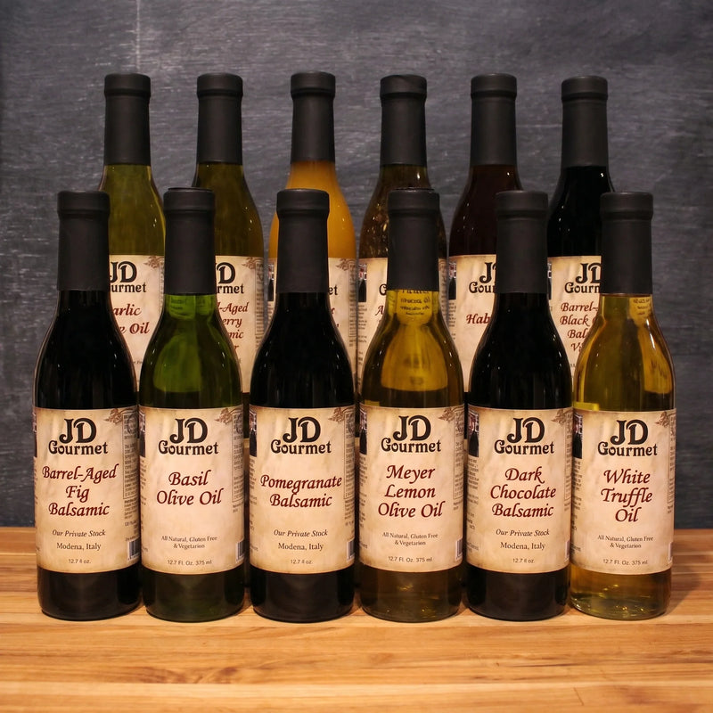 JD Gourmet Twelve Bottle Sampler gift set of twelve balsamic vinegar and olive oil bottles on rustic wood