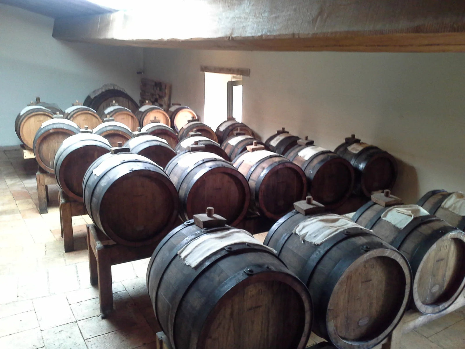 Wooden balsamic aging barrels stacked in an attic in Italy