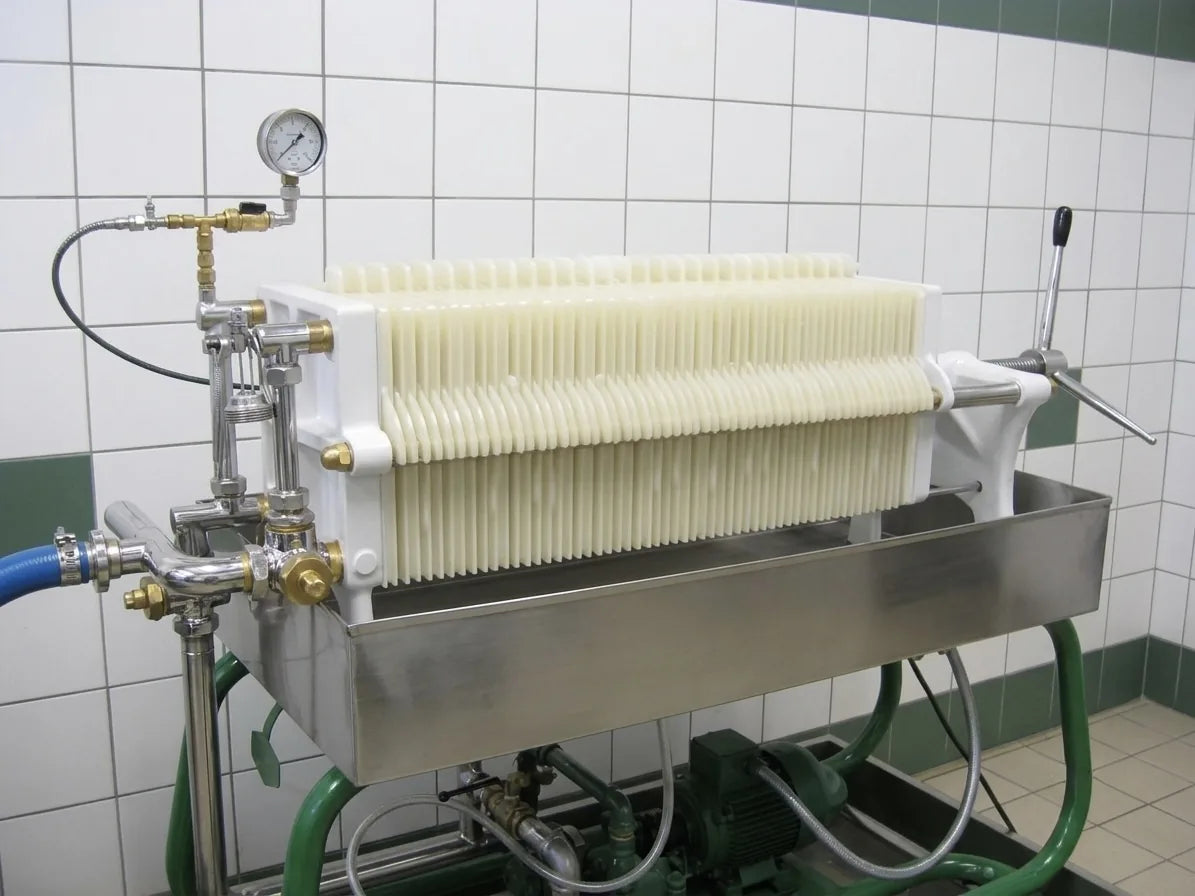 Cream-plate olive-oil filter press with brass fittings in an Umbrian mill