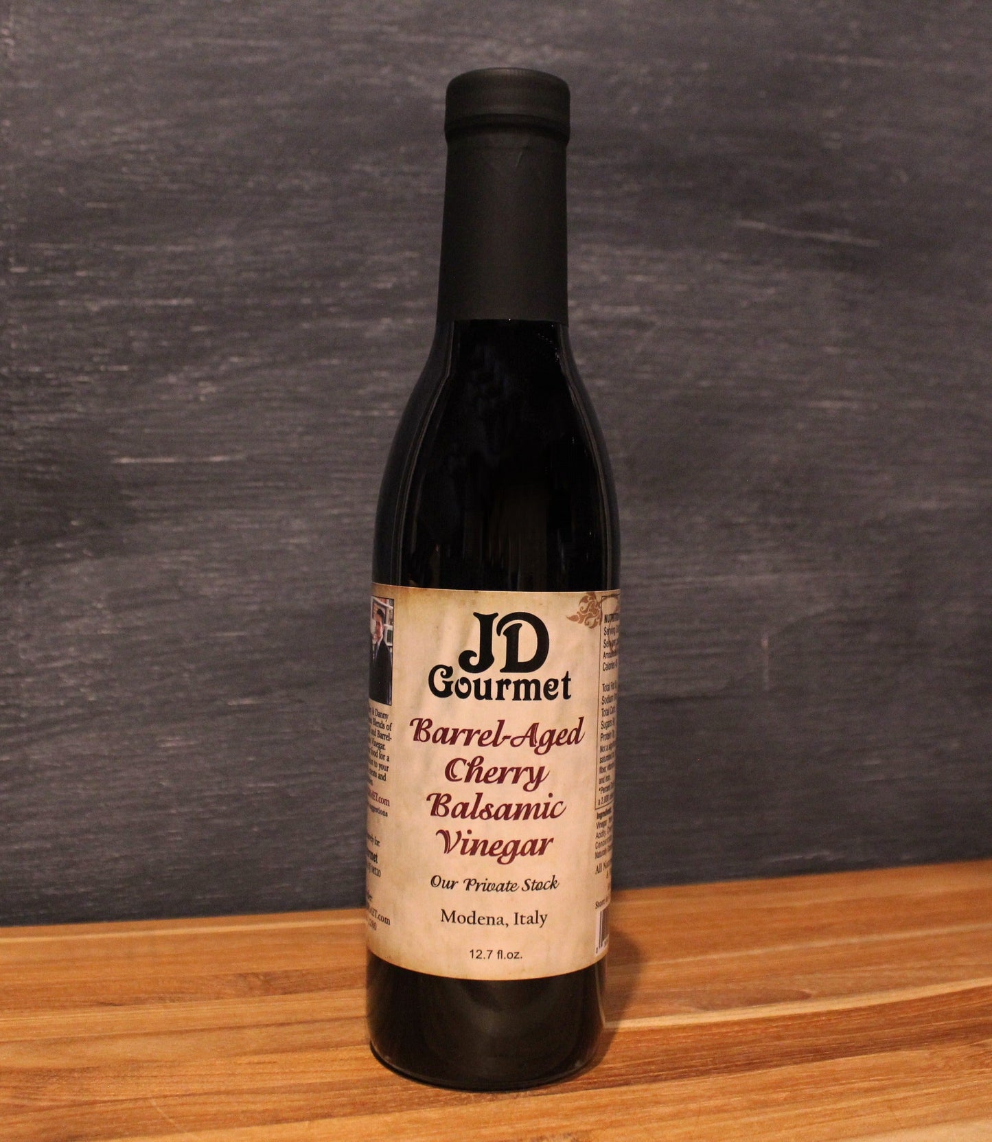 JD Gourmet Cherry Balsamic Vinegar — dark glossy balsamic in a clear bottle, dark sweet cherries, Modena