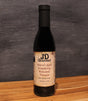 JD Gourmet Cranberry Balsamic — deep glossy dark balsamic in a clear glass bottle, made with real cranberry