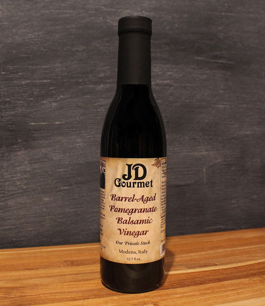 Bottle of JD Gourmet pomegranate balsamic vinegar, deep ruby red and glossy