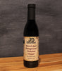 Bottle of JD Gourmet pomegranate balsamic vinegar, deep ruby red and glossy