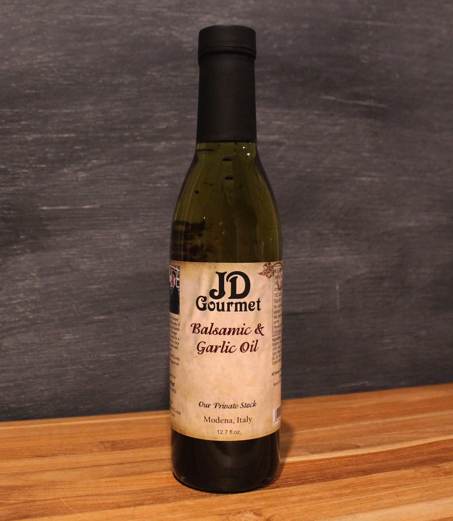 Bottle of JD Gourmet Balsamic Vinegar and Roasted Garlic Oil with chili and parsley